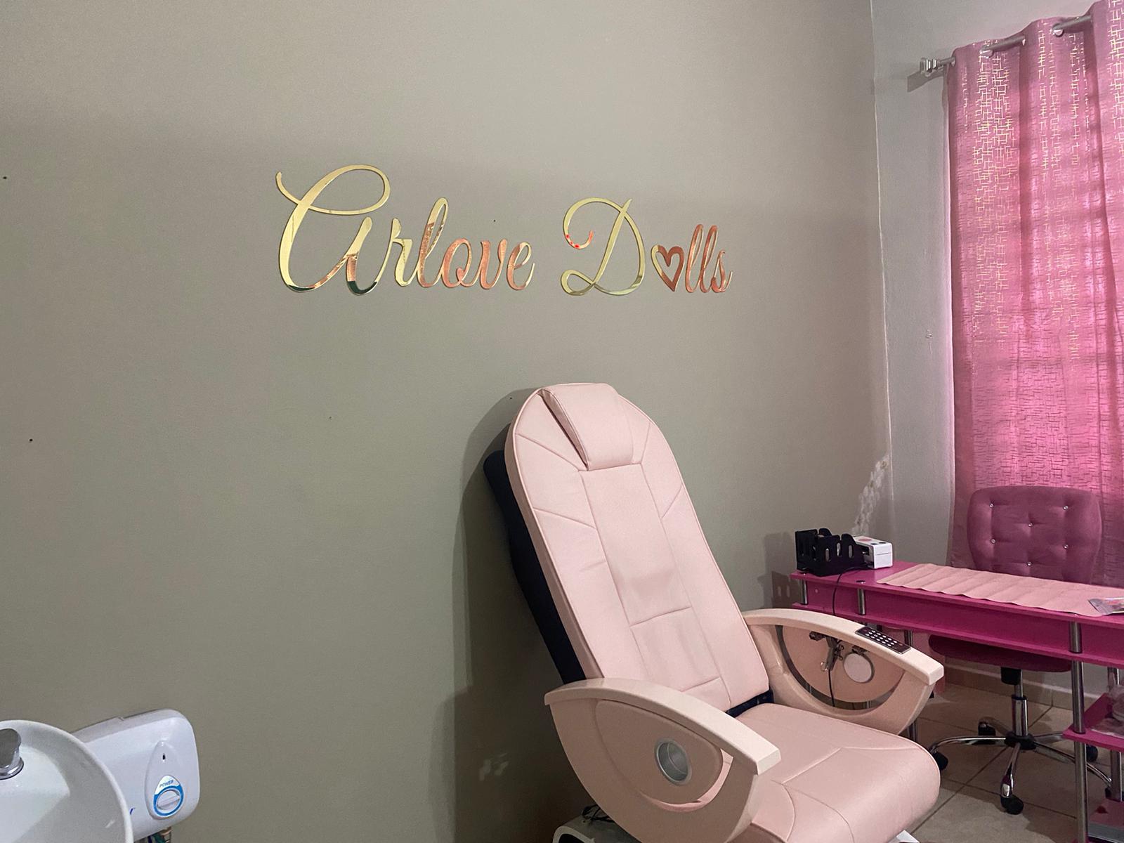 Gold acrylic script Arlove Dolls sign on salon wall